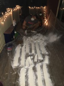 Sal, priming comically large foam feathers, in the dead of night.